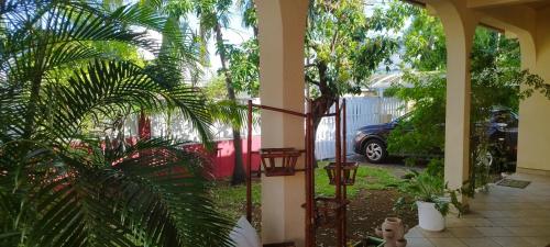 a house with a courtyard with palm trees and a car at Chambre chez l'habitant clim piscine wifi in Saint-Pierre