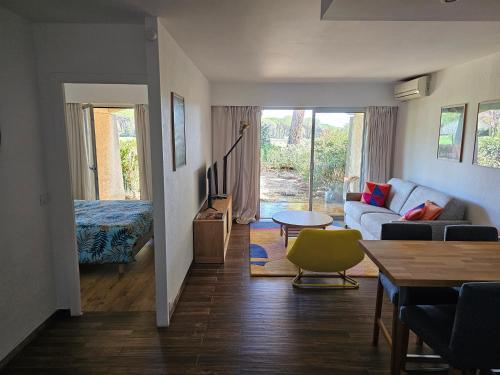 a living room with a couch and a table at Appartement golf de Valescure avec jardin in Saint-Raphaël