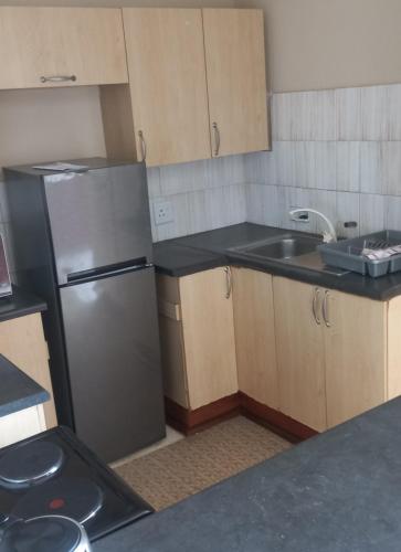 a kitchen with a stainless steel refrigerator and a sink at Afsaal 205 in Amanzimtoti