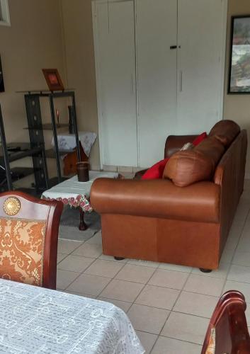 a living room with a brown couch and a table at Afsaal 205 in Amanzimtoti
