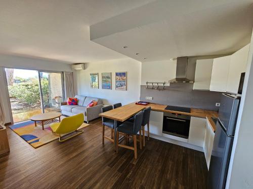 une cuisine et un salon avec une table et des chaises dans l'établissement Appartement golf de Valescure avec jardin, à Saint-Raphaël