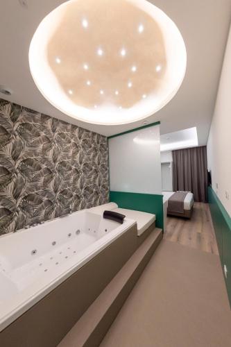 ナポリにあるSmart Hotel Napoliの大きな天井の客室で、大きなバスタブが備わります。