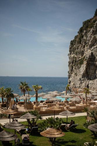 a resort with tables and umbrellas next to the ocean at Hotel Vista di Capri in Massa Lubrense