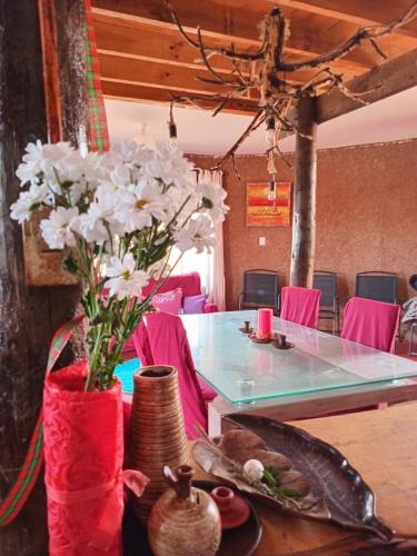 a table with a vase with white flowers in it at Ecoturismo El Refugio en La Colorada, Combarbalá in Combarbalá