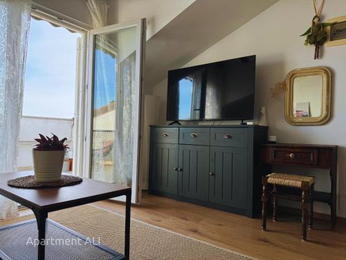a living room with a tv on top of a cabinet at Apartments ALI & EL - perfect for couples in Rovinj