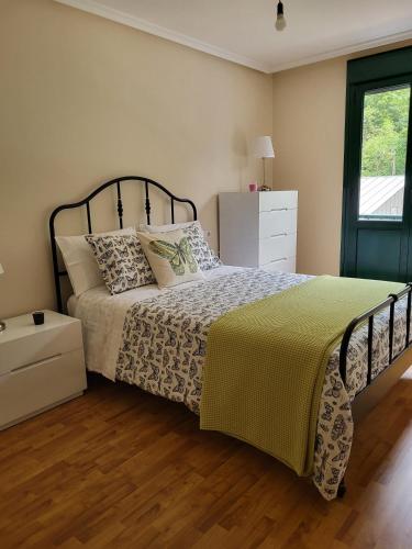 a bedroom with a bed with a yellow and white blanket at Belmonte in Belmonte de Miranda