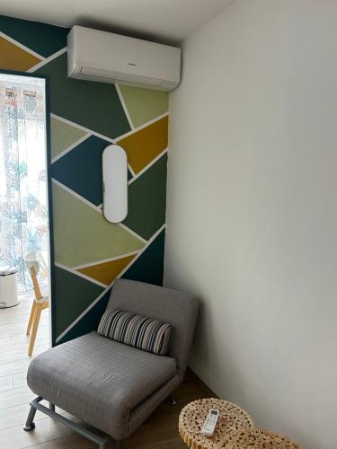 - un salon avec une chaise et un mur dans l'établissement Studio chaleureux et cosy à 10 minutes de la plage, à Sanary-sur-Mer