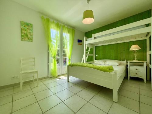- une chambre avec des lits superposés, un bureau et une chaise dans l'établissement Maison 4 pièces 7 couchages Saint Denis d'Oléron SDO000-076, à Saint-Denis-dʼOléron