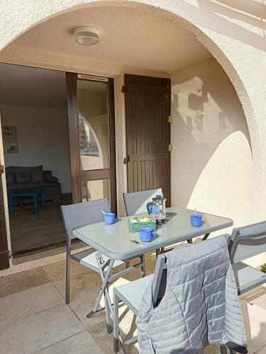 une table blanche et des chaises sur une terrasse dans l'établissement pied à terre Port Leucate, à Leucate-Plage
