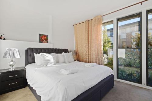a bedroom with a large bed and a large window at Belrose 2 Bed Holiday Home Free Parking in Belrose