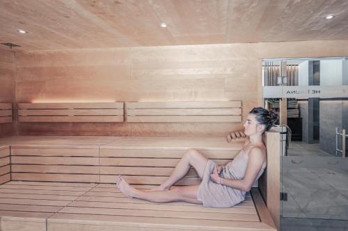 a woman is sitting in a sauna at Boutique Hotel LechZeit in Elmen