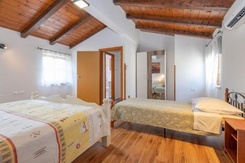 2 letti in una camera da letto con soffitti in legno di Vila Rimanici, a wonderful and sunny pet friendly villa a Pićan