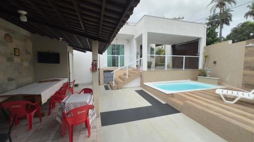 een terras met een tafel en stoelen en een zwembad bij Parque das águas in Guapé