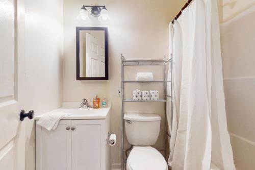 a bathroom with a toilet and a sink and a shower at The Cozy Nook in Bonney Lake