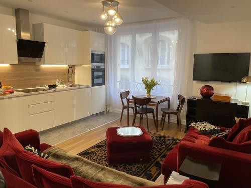 un salon avec un canapé rouge et une table dans l'établissement Cosy, chic, touristique, à Paris