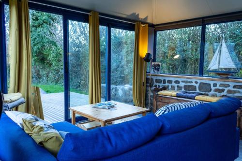 a living room with a blue couch and a table at Ty Grégoire - Campagne - Wi-Fi in Crozon
