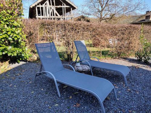 two blue chairs sitting on the ground in a yard at B&B La Belle Histoire Laforêt in Laforêt