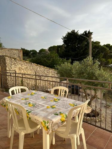 a white table and chairs on a balcony at Villa Baglio della Fico a 15 minuti dalla valle dei templi e dal mare in Racalmuto