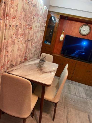 a dining room with a table and chairs and a tv at South-East-West Facing 3 BHK Lakeview Flat Howrah West Bengal in Hāora