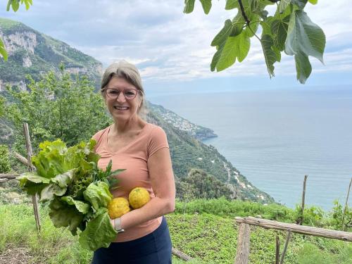 a woman holding a bunch of fruits and vegetables at Villa Antica Macina in Positano