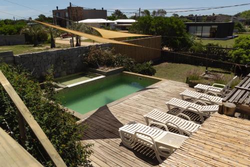 un grupo de sillas sentadas en una terraza con piscina en Océano Puro, en José Ignacio