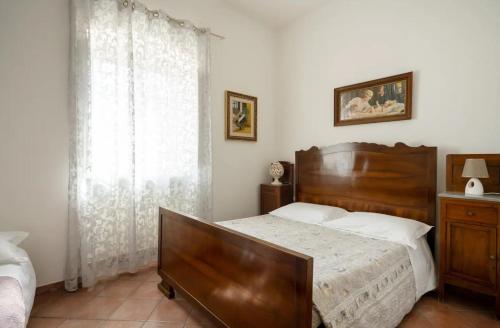 a bedroom with a large wooden bed and a window at Casale dello Zio, private pool by IL PUMO DI PUGLIA in Castellana Grotte