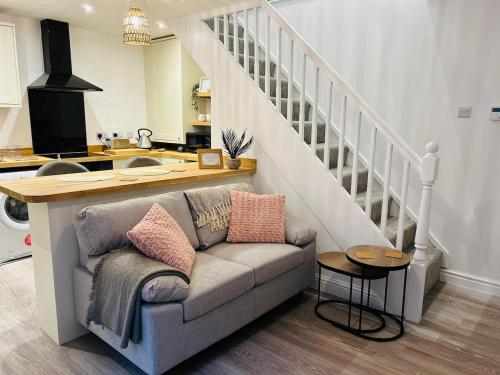 a living room with a couch and a staircase at Entire home in Eccleshall in Eccleshall