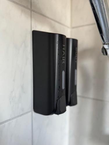 a soap dispenser hanging on a bathroom wall at Modernes Apartment - Top-Lage in Witten