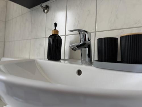 a bathroom sink with a soap dispenser on it at Modernes Apartment - Top-Lage in Witten