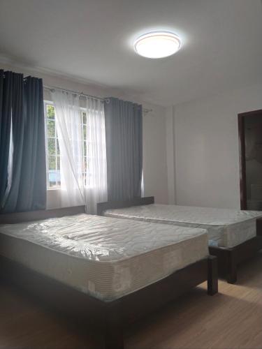 バギオにあるGibraltar Innの窓のある部屋にベッドが2つある