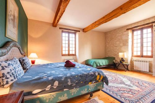 a bedroom with a large bed in a room with windows at Domaine du Bilé - Piscine et Jacuzzi privés in Solomiac