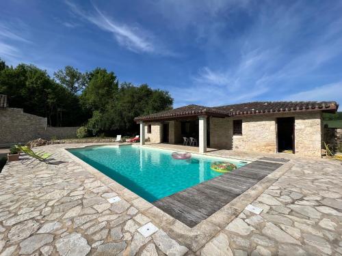 a swimming pool in front of a house at Domaine du Bilé - Piscine et Jacuzzi privés in Solomiac