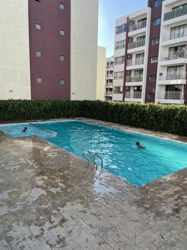 two people swimming in a swimming pool in a building at Naji Homes in Athi River