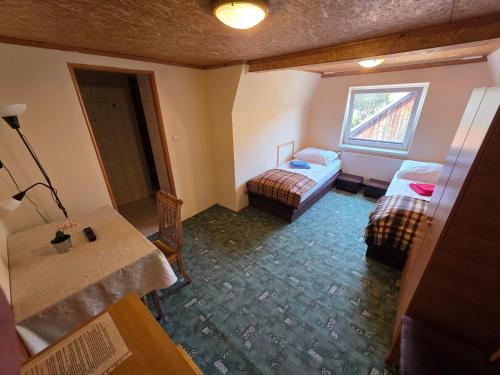 a room with two beds and a table and a window at Willa pod Babkami in Tylicz