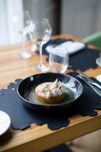 a plate of food on a table with wine glasses at Hôtel de Boisgelin in Pléhédel