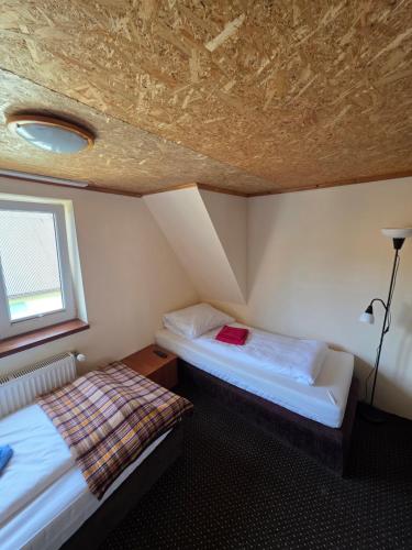a bedroom with two beds in a room with a ceiling at Willa pod Babkami in Tylicz