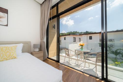 une chambre avec un lit et un balcon avec une table dans l'établissement Goldena Twin Project - 3 Bedrooms Pool Villa, à Kamala Beach