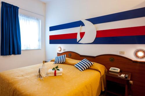 a bedroom with a bed with a flag on the wall at Hotel La Carruba in Cetraro