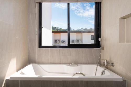 une baignoire dans une salle de bain avec une fenêtre dans l'établissement Goldena Twin Project - 3 Bedrooms Pool Villa, à Kamala Beach