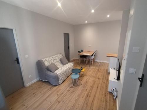 un salon avec un canapé et une table dans l'établissement Appartements avec garage privé - Latre Location, à Lourdes