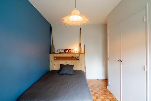 une chambre avec un lit et un mur bleu dans l'établissement Villa Lucio, à Parentis-en-Born