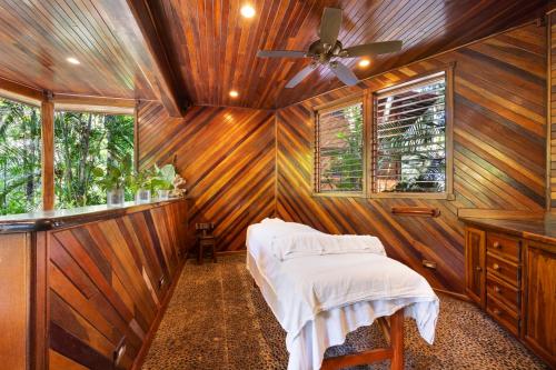 a room with wooden walls and a bed with white sheets at Tambor Tropical Beach Resort- Adults Only in Tambor