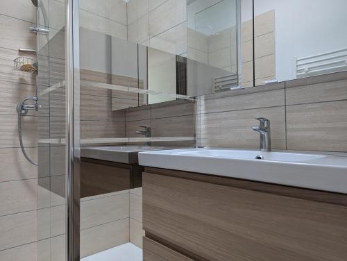 une salle de bain avec un lavabo et une douche dans l'établissement Sol-y-Days le Cormoran appartement vue sur port de plaisance, au Grau-du-Roi