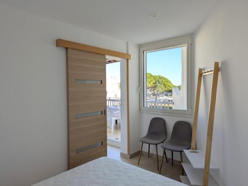 - une chambre avec deux chaises à côté d'une fenêtre dans l'établissement Sol-y-Days le Cormoran appartement vue sur port de plaisance, au Grau-du-Roi
