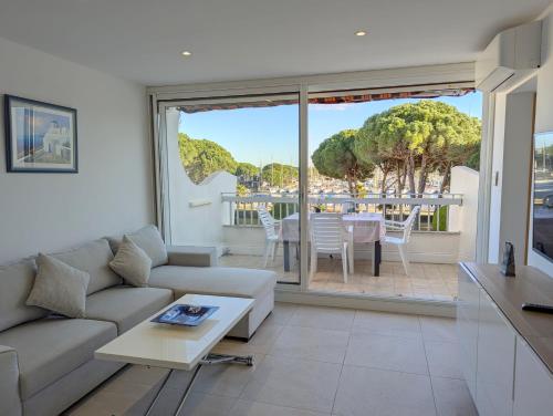 un salon avec un canapé et une table dans l'établissement Sol-y-Days le Cormoran appartement vue sur port de plaisance, au Grau-du-Roi