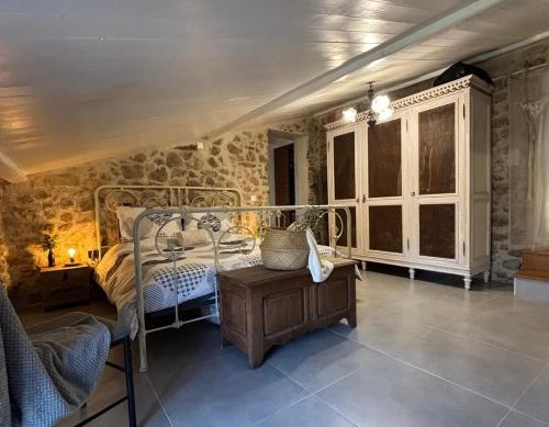 - une chambre avec un lit dans une pièce dotée de murs en pierre dans l'établissement Bergerie Mémoire du Temps Logement entier dans maison partagée, à Roquefort-les-Pins