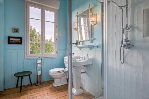 une salle de bain avec toilettes, lavabo et fenêtre dans l'établissement Villa Gustave, à Envermeu