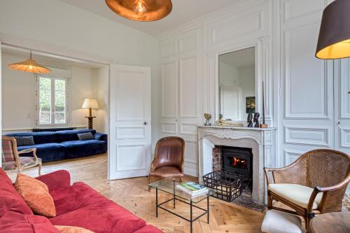 - un salon avec un canapé rouge et une cheminée dans l'établissement Villa Gustave, à Envermeu