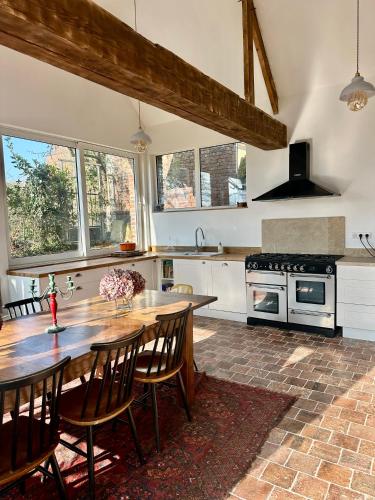 une cuisine avec une table en bois et quelques chaises dans l'établissement Villa Gustave, à Envermeu