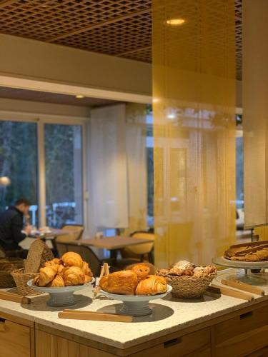 Un mostrador con cuencos de pan y cestas de comida. en Le Moulin Des Ruats, en Avallon